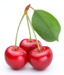 Three cherries with leaf isolated on a white background.